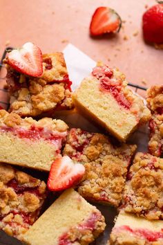 strawberry crumb bars stacked on top of each other with strawberries in the background