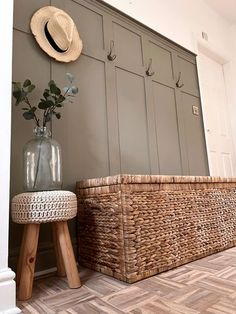 a basket and vase on the floor next to a wall