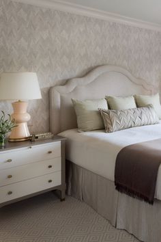 a white bed sitting next to a window in a bedroom