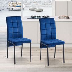 two blue chairs sitting next to each other in front of a kitchen counter top with an oven