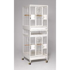 three white bird cages stacked on top of each other in front of a gray background