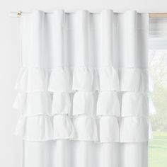 a white curtain with ruffled edges hanging in front of a window