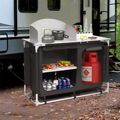 a camper trailer with food and drinks on the table next to an open fire extinguisher