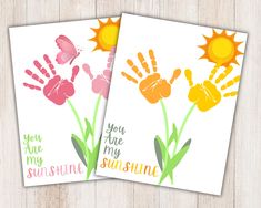 two cards with hand prints on them, one says you are my sunshine and the other says you are my sunshine