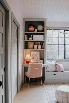 a room with a chair, bookshelf and window