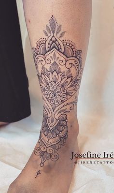 a woman's leg with a tattoo on it and an intricate design in the center