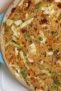 a pan filled with noodles and vegetables on top of a stove