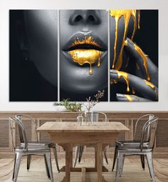 a woman's lips with yellow dripping paint on them in front of a dining room table