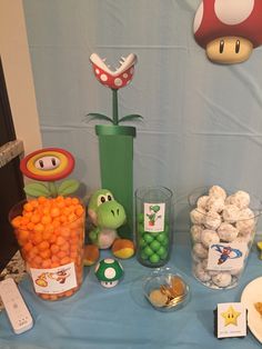 the table is set up with candy, candies and mario mushroom decorations