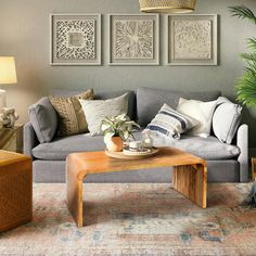 a living room with couches, tables and pictures on the wall above them in shades of gray