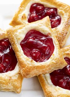 four small pastries with jelly filling on them