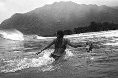 a woman is wading in the water with her dog