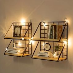 three shelves with books and lights on them