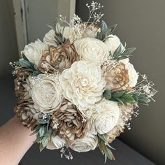 the bridal bouquet is made up of flowers and greenery, including pine cones