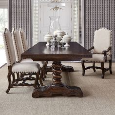 a dining room table with six chairs and a chandelier hanging from the ceiling