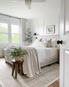 a bedroom with white walls and carpeted flooring has a large bed in the corner