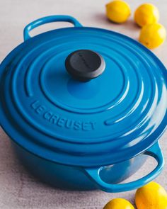 a blue casserole dish with lemons around it