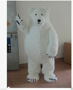 a large white polar bear standing in front of a wall with his hand up to the side