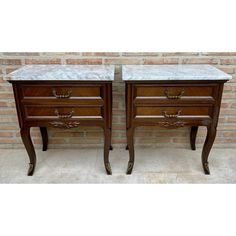 pair of marble top nightstands in walnut finish