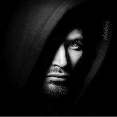 black and white photograph of a man in hoodie looking to the side with his eyes closed