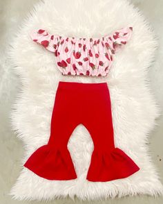 "Beautiful red bell pants and crop top. Perfect for strawberry themed birthdays.  The little bow sizes Newborn-2t comes on nylon, the 3t sizes and up will come on alligator clip  The set is made of ribbed stretchy knit fabric. Runs true to size. I won't recommend sizing up.  Size-inseam of leggings/waist  NB-6\"/13\" 0-3m-7\"/14.5\" 3-6m-8\"/15.5\" 6-9m- 9\"/16\" 9-12m-10.5\"/16.5\" 12-18m-11.5\"/17.25\" 18-24m-13\"/18\" 2-3t-14.5\"/18.5 3-4t-15\"/19\" 4-5y-15.5\"/19.5\" 5-6y-16\"/20\"" Cute Strawberry Print Sets For Spring, Fitted Strawberry Print Bottoms For Summer, Cute Red Sets For Spring, Cute Strawberry Print Bottoms For Spring, Pink Fitted Bottoms With Strawberry Print, Fitted Pink Bottoms With Strawberry Print, Playful Red Ruffled Sets, Cute Red Ruffled Bottoms, Playful Red Bottoms For Spring