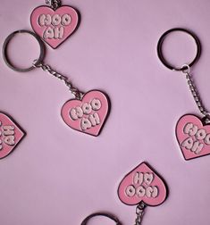 four pink heart shaped key chains with the word boo hoo written on one side