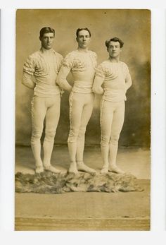 three men standing next to each other in front of a black and white photo