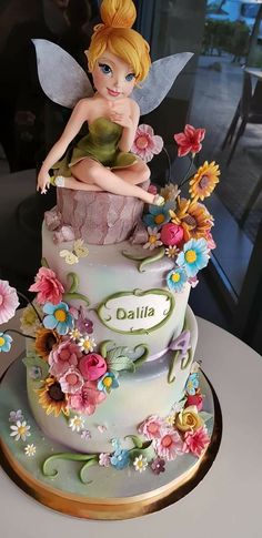 a cake with a fairy sitting on top of it