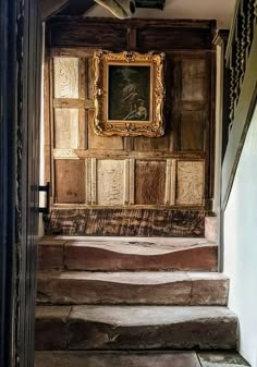 an old wooden staircase leading up to a painting on the wall