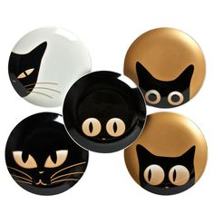 four black and white plates with cats painted on the front, one has gold eyes