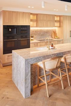 a large kitchen with an island counter and chairs