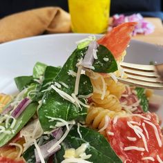 a white plate topped with pasta and spinach