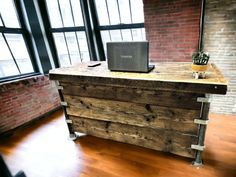 an office desk made out of pallet wood with a laptop on top and a plant in the middle