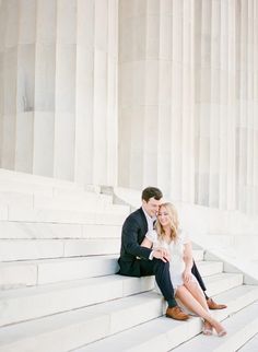 an engaged couple sitting on the steps of the lincoln memorial