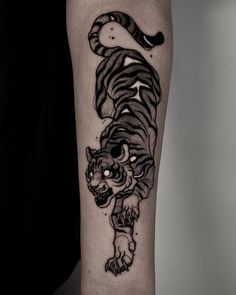 a black and white tiger tattoo on the arm