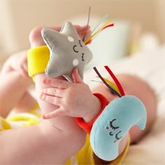 a baby is holding a toy in its hand