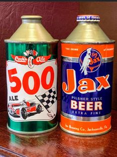 two cans of beer sitting on top of a wooden table