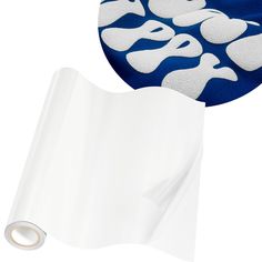 a roll of white paper next to a blue and white background with an image of skulls on it