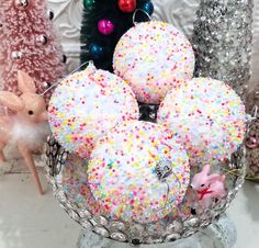 a glass bowl filled with donuts covered in sprinkles