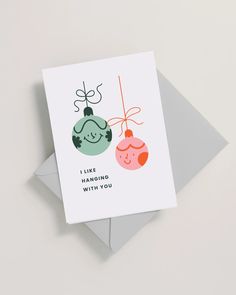 a card with two christmas ornaments hanging from it's side and the words i like hanging with you