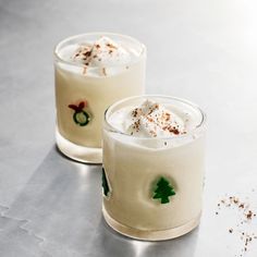 two glasses filled with drinks sitting on top of a table