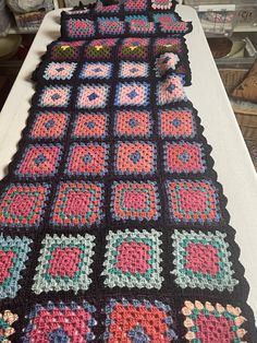 a crocheted blanket is laying on a table