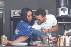 a man and woman in the kitchen preparing food