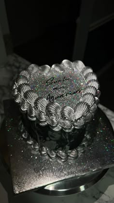 a glass bowl sitting on top of a metal plate covered in holographics