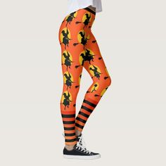 a woman wearing orange and black halloween leggings