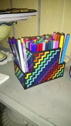 a basket filled with pens and markers on top of a counter