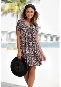 This casual dress with a loose fit and cute print is perfect for a fun day out. Casual Printed V-neck Mini Dress, Casual Mini Length Printed Dress, Trendy Black Mini Dress For Vacation, Flowy Black Printed Mini Dress, Printed Relaxed Fit Dresses For Day Out, Relaxed Fit Printed Dress For Day Out, Casual V-neck Daytime Dress, Casual Knee-length Mini Dress For Daytime, Casual Printed Mini Dress For Spring