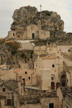 an old town with stone buildings and a cross on top