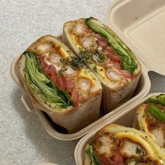 two plastic containers filled with sandwiches on top of a table