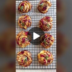 twelve cranberry and brie flower pastries on a wire rack with a video screen